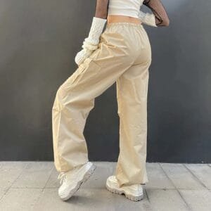 Look décontracté en pantalons cargo beiges et top blanc, chaussures sportives pour un style moderne.