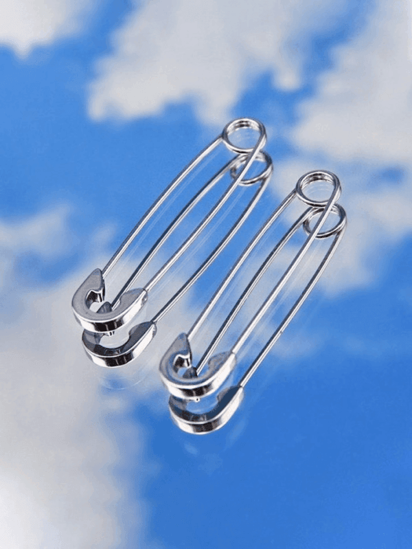 Boucles Doreilles Trombone Argentées Élégantes Sur Fond De Ciel Bleu Et Nuages Blancs.