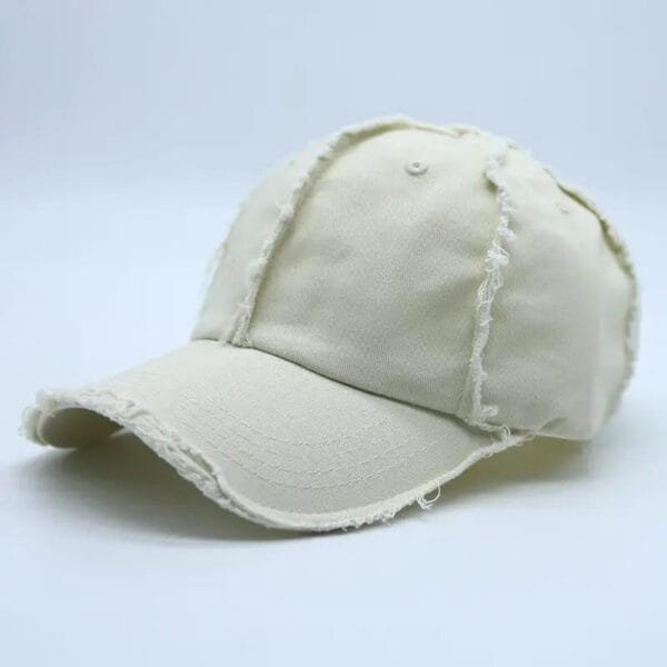 Casquette Beige Vintage Avec Détails Effilochés Pour Un Style Décontracté Et Chic.