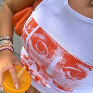 Style Dété Décontracté Avec Tank Top Graphique Et Boisson Orange Vibrante En Extérieur.