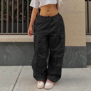 Tenue décontractée avec pantalons cargo, top blanc et sneakers tendance en milieu urbain.