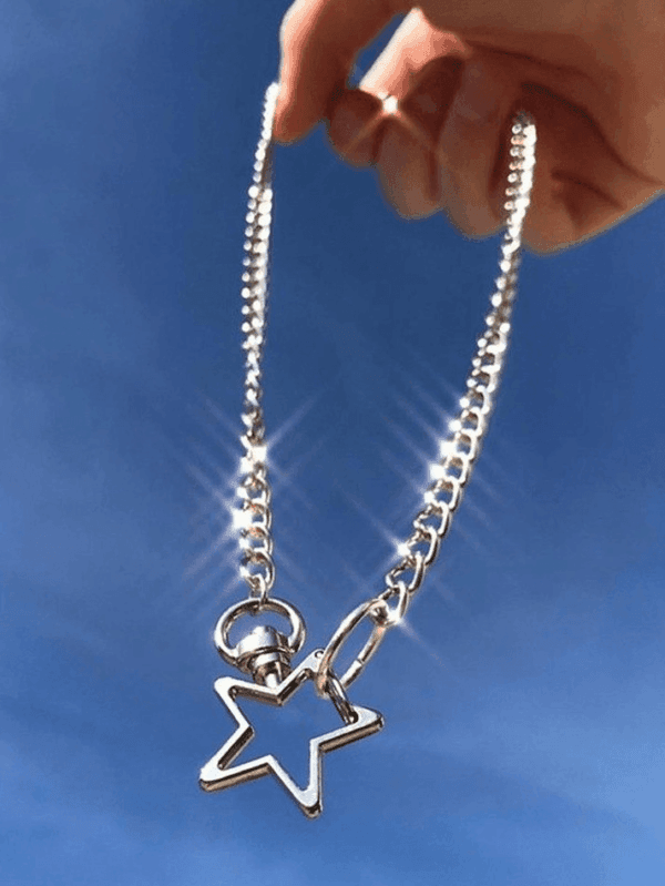 Chaîne En Argent Avec Pendentif Étoile, Capturant Élégance Et Liberté Sous Un Ciel Bleu.