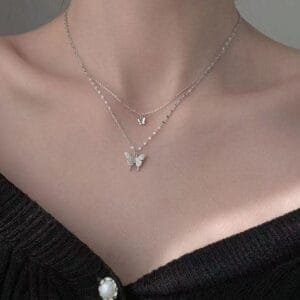 Superbe Collerette Argent Avec Pendentif Papillon Sous Un Cardigan Élégant Et Décontracté.