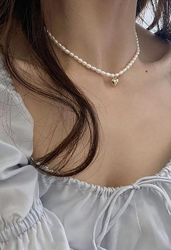 Collier En Perles Et Blouse Légère Pour Une Élégance Douce Et Féminine.