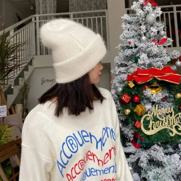 Femme Stylish En Pull De Noël Et Bonnet, Devant Un Arbre De Noël Chaleureux Et Décoré.