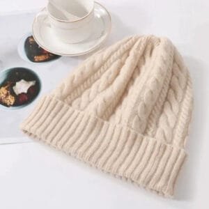 Bonnet crème en tricot câblé, parfait pour un hiver confortable et tendance.