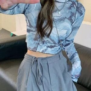 Tenue tendance : Crop top marbré bleu et jupe haute grise pour un look décontracté.