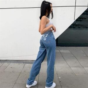 Femme Urbaine En Crop Top Et Jeans, Affichant Un Style Décontracté Et Confiant.