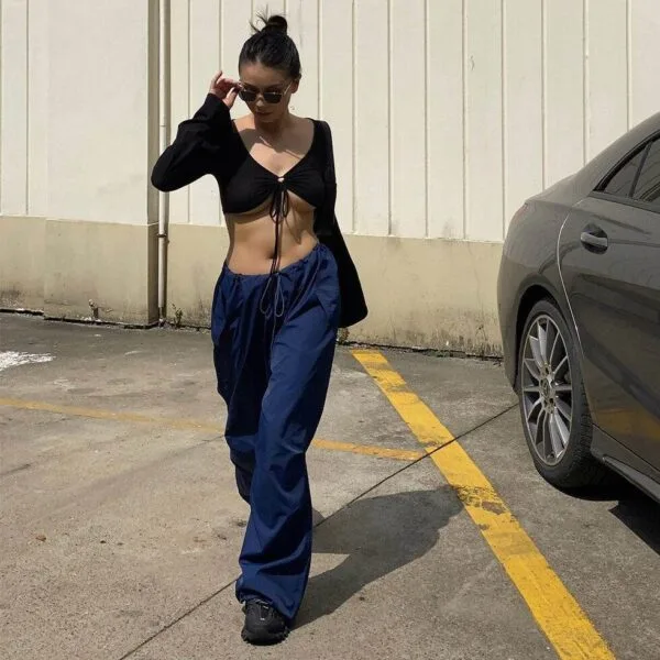 Femme En Style Urbain Décontracté, Top Noir Et Pantalon Bleu, Marchant Avec Assurance.