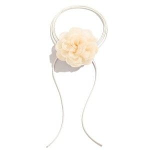 Accessoire capillaire élégant avec fleur pale, idéal pour un style romantique et doux.