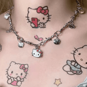 Tattoages Hello Kitty colorés et collier Y2K, un style alternatif vibrant et ludique.