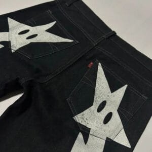 Jeans Noirs Avec Graphiques Étoilés Audacieux Et Ludiques Pour Un Look Moderne Et Unique.