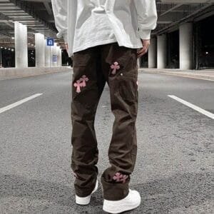 Mode urbaine avec pantalon cargo et touches roses sur une rue moderne et vide.