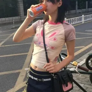 Femme Jeune Et Stylée En Top Kawaii, Savourant Une Boisson Sur La Rue Urbaine.