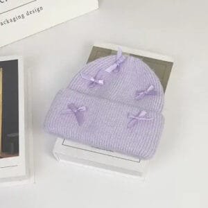 Bonnet lilas tricoté avec rubans délicats pour un style élégant et tendance.