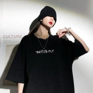 Jeune Femme En T-Shirt Noir Oversize, Style Urbain Avec Accessoires Argentés.