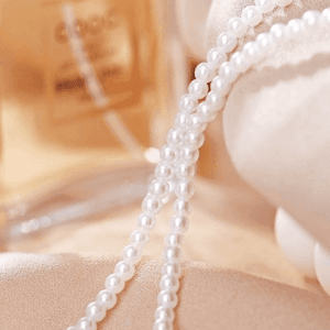 Perles Scintillantes Et Flacon De Parfum : Une Harmonie De Luxe Et Délégance.