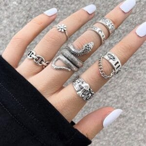 Bagues en argent et manucure blanche, style Y2K au look moderne et élégant.