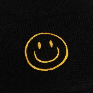 Chapeau Noir Confortable Avec Visage Souriant Jaune, Alliant Chaleur Et Style Ludique.