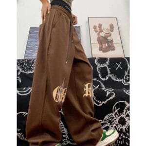 Personne En Streetwear : Pantalon Oversized Chocolat Et T-Shirt Olive, Style Contemporain.