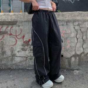 Look tendance : tenue streetwear chic contre mur en béton urbain.