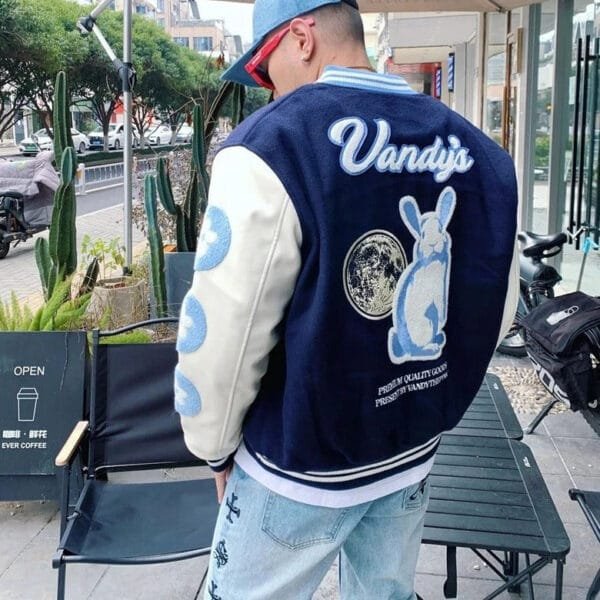 Homme En Veste Varsity Moderne Avec Motif De Lapin, Jeans Décontractés Et Ambiance Urbaine.