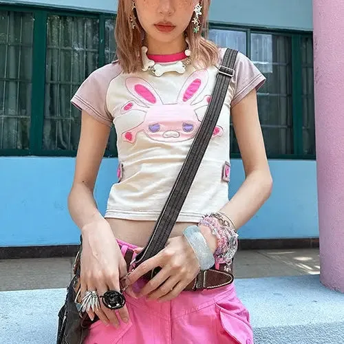 Jeune Personne En Tenue Colorée, Top Lapin Et Shorts Roses, Pose Confiante Dans Un Décor Urbain.