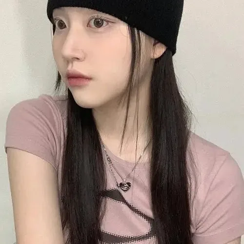 Jeune Femme En Béret Noir, Portant Un T-Shirt Rose, Dans Un Décor Minimaliste.